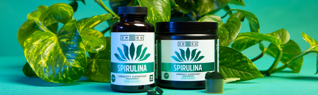 Spirulina capsules and powder next to leaves.