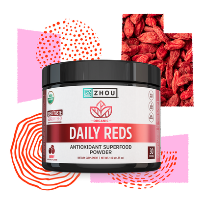 A container of Zhou Nutrition Daily Reds supplement with berry graphics and abstract red patterns in the background.