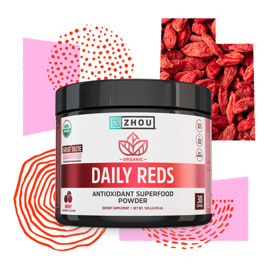 A container of Zhou Nutrition Daily Reds supplement with berry graphics and abstract red patterns in the background.